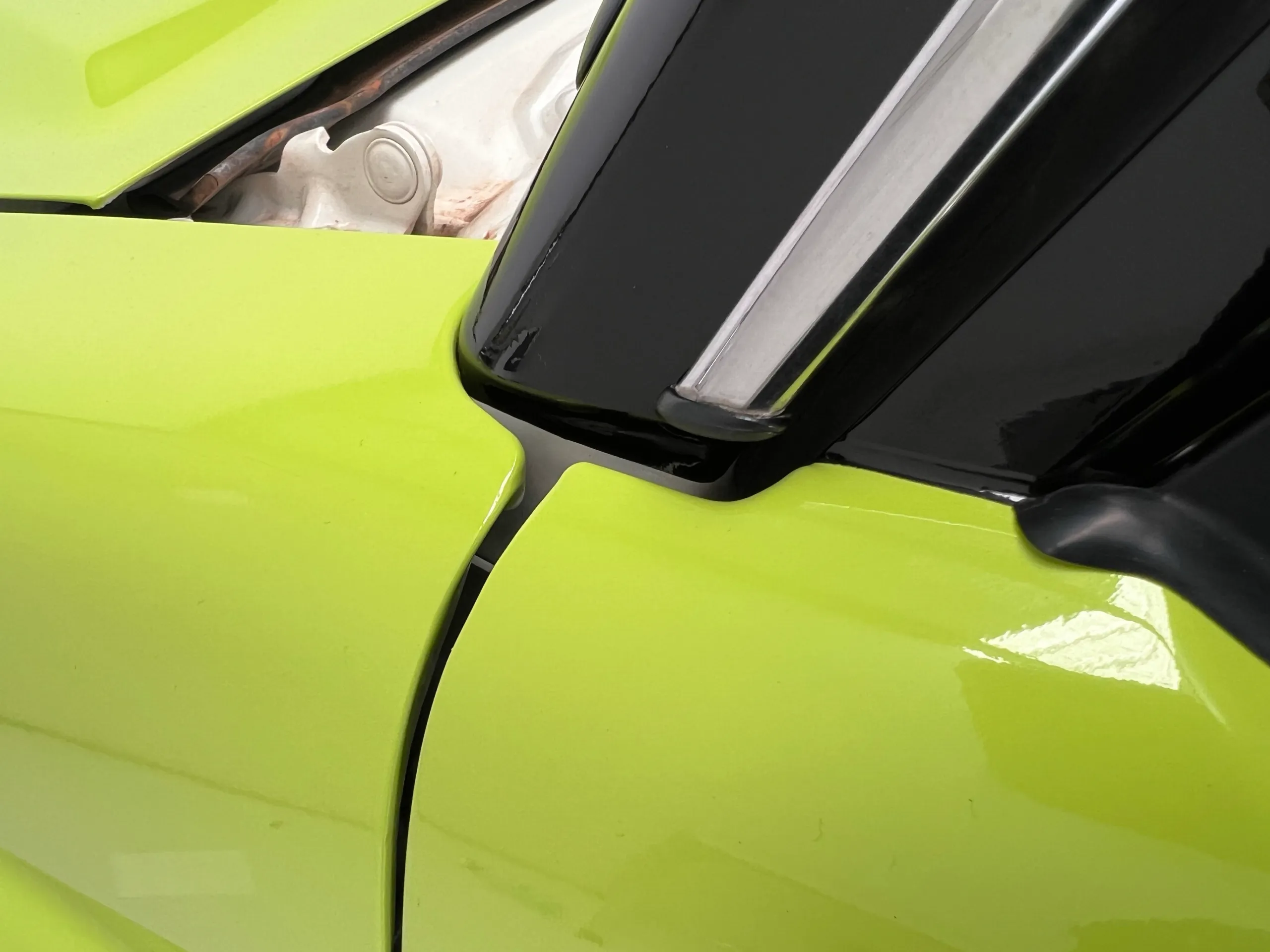 Lime green film neatly fitted beside black mirror trim