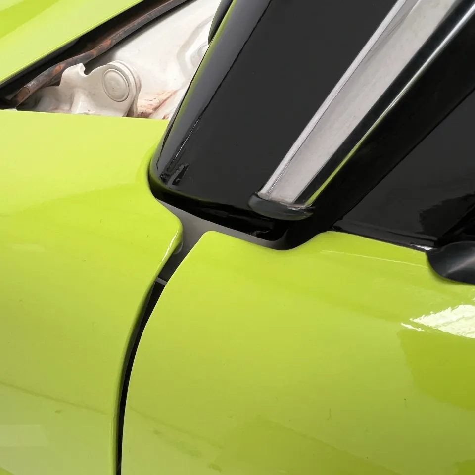 Lime green film neatly fitted beside black mirror trim