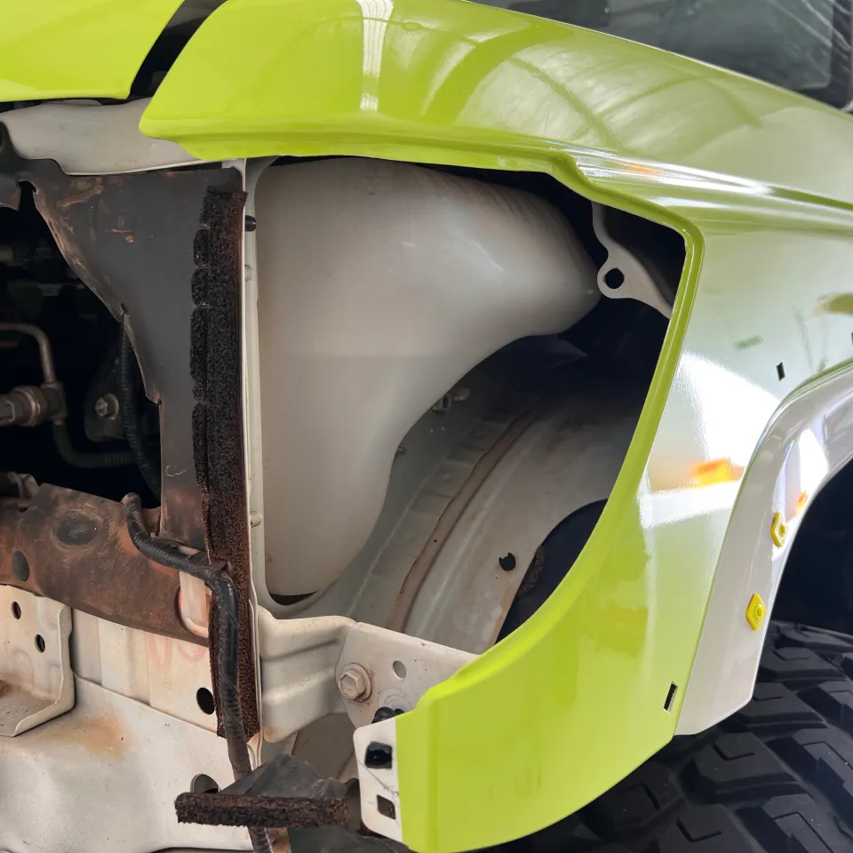 Lime green body panel with the headlight removed during installation