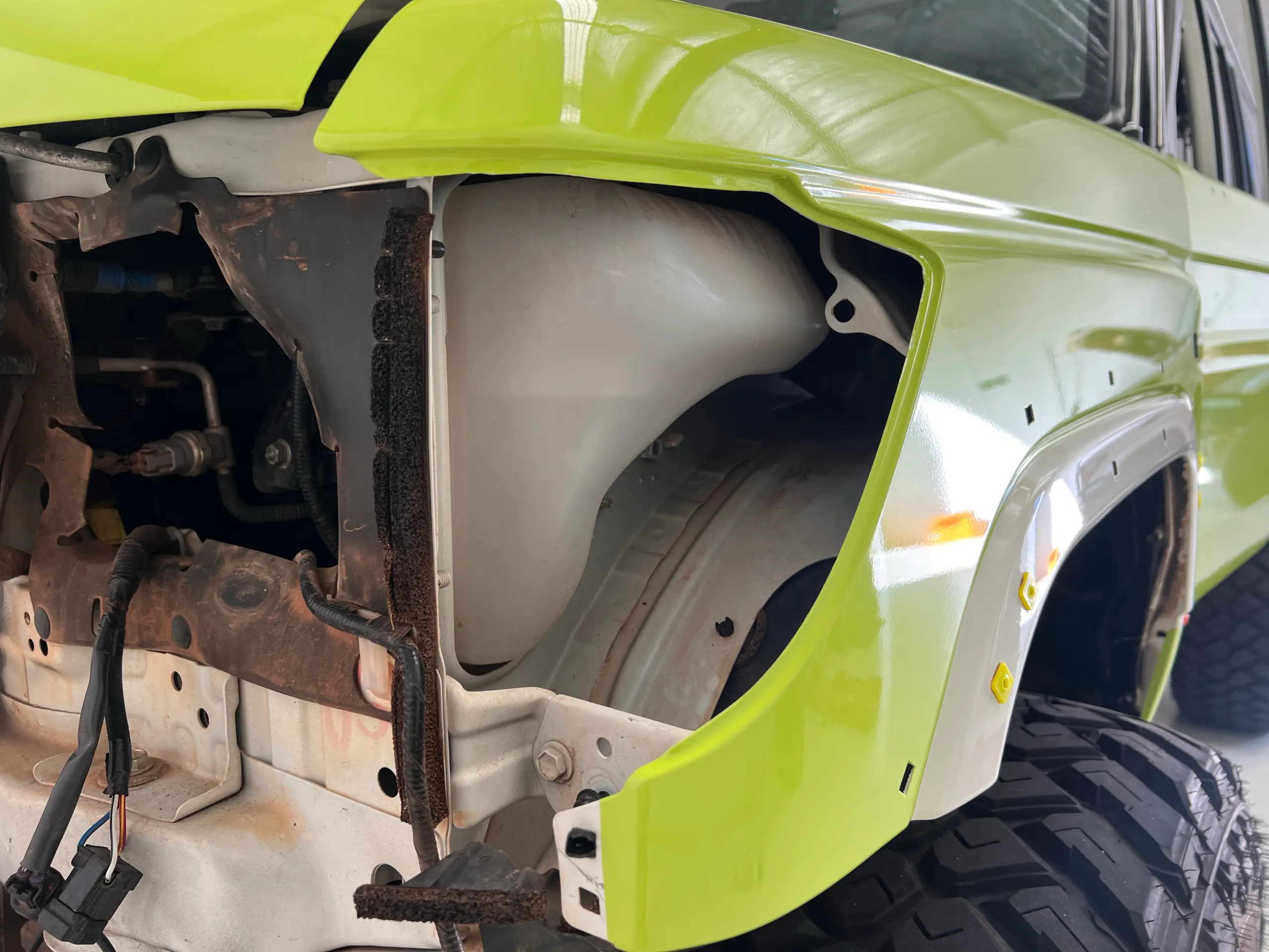 Lime green body panel with the headlight removed during installation