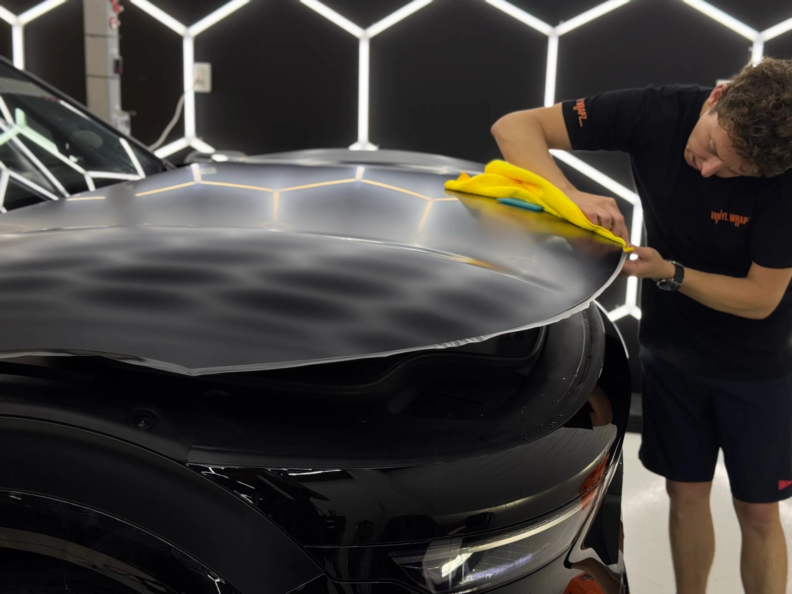 Installer smoothing film over the Zeekr bonnet during satin conversion